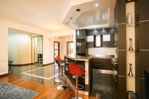 埃里温Katsin Building ! 3 Bedroom Luxury Apartment with 2 Bathrooms!的厨房配有黑色橱柜和红色椅子