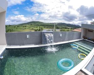 a swimming pool with a waterfall and a water slide at Ecos da Serra in Bezerros