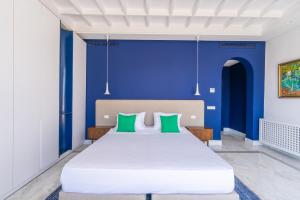 a bedroom with a large white bed with green pillows at Dar Elyssa in Sidi Bou Saïd