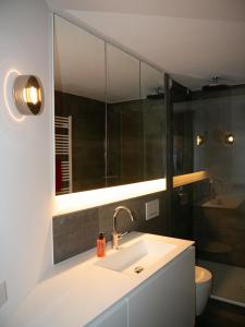 a bathroom with a sink and a mirror and a toilet at Urban Art Living - Your temporary home in Niederdorla