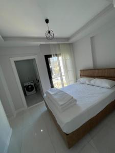 a bedroom with a large bed and a window at Çakıl suit otel restaurant in Merdivenlikuyu