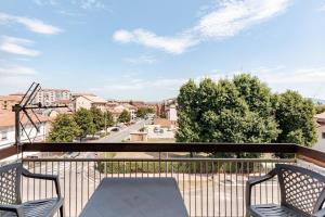 a balcony with two chairs and a view of a street at Casa Del Volo 10 Min Turin Airport & Juve Stadium in Borgaro Torinese