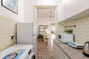 a kitchen with a white refrigerator and a table at Casa Del Volo 10 Min Turin Airport & Juve Stadium in Borgaro Torinese