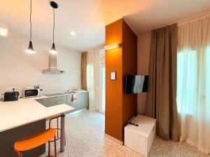 a room with a kitchen with a counter and a tv at Il Giardino degli Ulivi PT in Lissone
