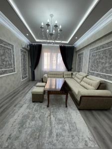 a living room with a couch and a table at Samarkand Central Luxury Apartment in Samarkand