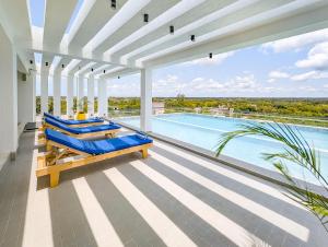 an indoor pool with blue lounge chairs and a swimming pool at Marikeka Hotel in Galu