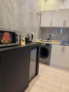 a kitchen with a microwave on a counter and a dishwasher at Luxurious studio with a modern design - Al Faisaliah neighborhood in Jeddah