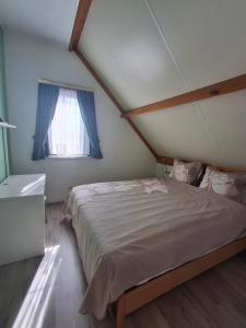 a bedroom with a large bed with a window at De zeebries in De Haan
