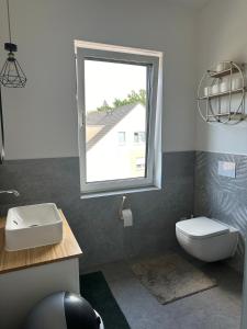 a bathroom with a white toilet and a window at Neubau FeWo in Haltern am See in Haltern