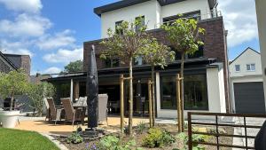 a home with a patio with chairs and trees at Neubau FeWo in Haltern am See in Haltern