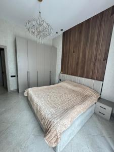 バクーにあるPolo residence Seabreazeの大きなベッドとシャンデリアのある寝室