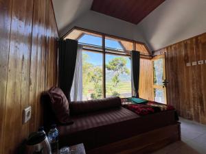 a room with a window and a couch in front of it at Ihab Villa Sembalun by RHM Indonesia in Sembalun Lawang