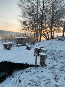 a snow covered picnic table and bench on a snow covered field at Astrolipa in Zyzdrojowy Piecek