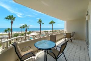 einen Balkon mit Tisch und Stühlen sowie Strand in der Unterkunft BeachClub A406-3bed3.5 New Rental-Beachfront condo in Gulf Shores