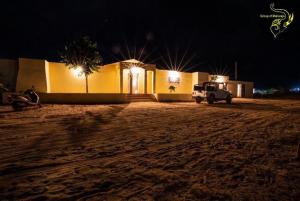 una casa con un'auto parcheggiata davanti di notte di Dunes Heritage Desert Camp a Jaisalmer
