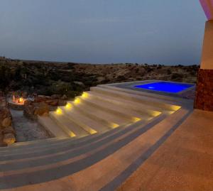 an outdoor staircase leading to a swimming pool at night at Leeuwkuil Lodge in Philipstown
