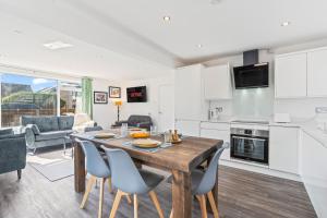 a kitchen and living room with a wooden table and chairs at Long-Stay Ready in NG13 Bungalow, sleeps 6 in Bingham