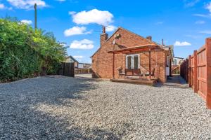 a cottage with a gravel driveway in front of a house at Long-Stay Ready in NG13 Bungalow, sleeps 6 in Bingham