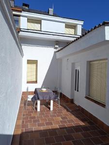 a patio with a table and chairs on a building at La chorranca in Valsain