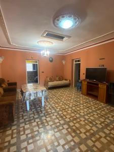 a living room with a couch a table and a tv at Bellahcen house in Nador