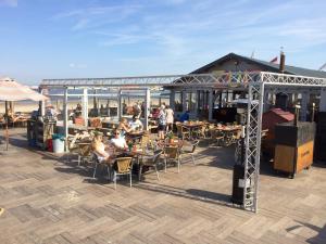 a group of people sitting at tables on a patio at Sea & Dunes in Scheveningen