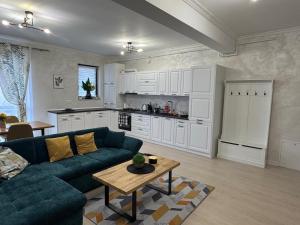 Una sala de estar con un sofá azul y una cocina. en RakanStudioApart, en Timisoara