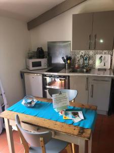 a kitchen with a table with a blue cloth on it at La Maison de Noémie in Leucate