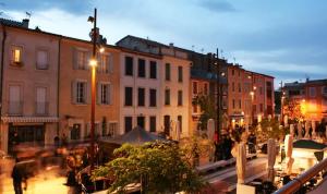 a group of buildings on a city street at night at La Maison de Noémie in Leucate