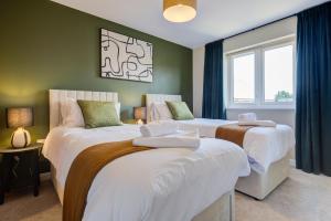 two beds in a room with green walls at Marriott House in Bourne