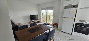 a kitchen and dining room with a table and a refrigerator at 1 bedroom beachfront unit in Karikari Peninsula