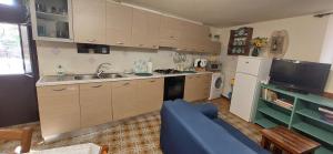 Una cocina con gabinetes de madera y un sofá azul. en Locazione Turistica LBS, San Giacomo , Spoleto, en San Giacomo