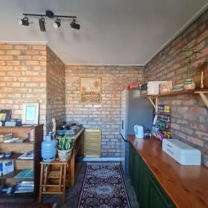 a kitchen with green cabinets and a brick wall at Your home in the Cape in Cape Town