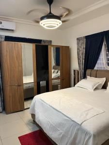 a bedroom with a large white bed and a window at Self compound beautiful three bedroom house in Accra