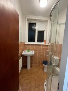 a bathroom with a sink and a toilet and a window at Budget Stay In Luton 02 02 in Luton