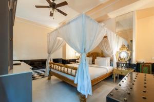 a bedroom with a canopy bed with a ceiling fan at The Royal Retreat Resort & Spa in Udaipur +75 photos