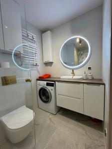 a bathroom with a sink and a washing machine at Apartament - Mieszkanie, nocleg przy Centrum Zdrowia Dziecka - Warszawa Międzylesie Wawer - Dzięcieliny 15 in Warsaw