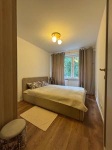 a bedroom with a large bed and a window at Apartament - Mieszkanie, nocleg przy Centrum Zdrowia Dziecka - Warszawa Międzylesie Wawer - Dzięcieliny 15 in Warsaw