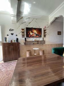 a living room with a table and a fireplace at Youness House in Aourir