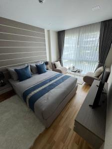 a bedroom with a large bed with blue pillows at 1 bedroom apartments in Whale Marina Condo Pattaya Thailand in Na Jomtien