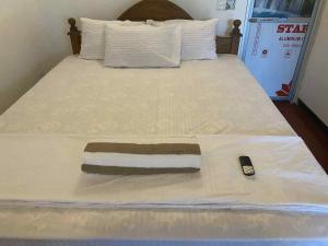 a bed with a blanket and a remote control on it at Kavee Waves Hiriketiya in Dickwella