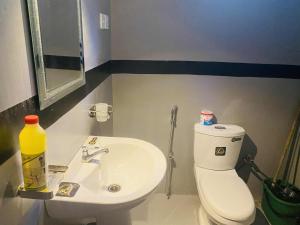 a bathroom with a white toilet and a sink at Kavee Waves Hiriketiya in Dickwella