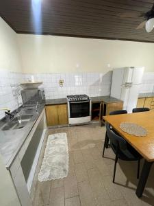 a kitchen with a sink and a table with a table at Recanto dos Goianos 2 - Prado Bahia in Prado +9 photos