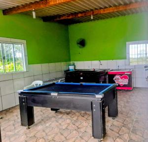 a pool table in a room with green walls at Chacara Rancho da Cris in Ibiúna