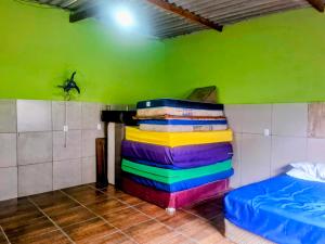 a stack of colorful towels in a room with a bed at Chacara Rancho da Cris in Ibiúna +25 photos