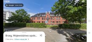 a brick building with a sign in front of it at Apartament 11 Wolności in Brzeg