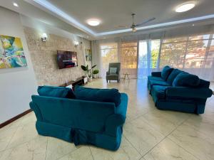 a living room with two blue couches and a tv at The rooftop oasis apartment in Mombasa