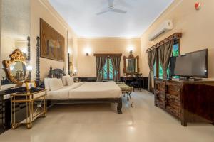 a bedroom with a bed and a flat screen tv at The Royal Retreat Resort & Spa in Udaipur