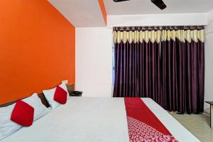 a bedroom with a bed with red and white at Hotel O Flagship Hotel Maa Shitla in Patna