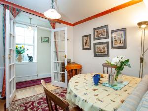 ein Esszimmer mit Tisch und Couch in der Unterkunft Port View Cottage in Shaldon