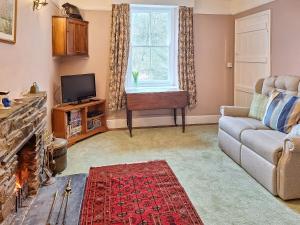 un soggiorno con un divano e una TV di Carreg Yr Eos - Cottage a Fishguard